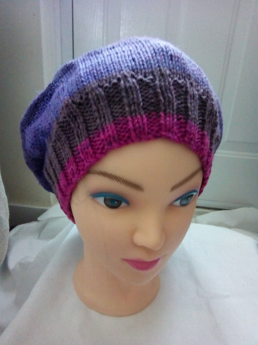 Knitted beret style hat in multiple shades of purple and pink